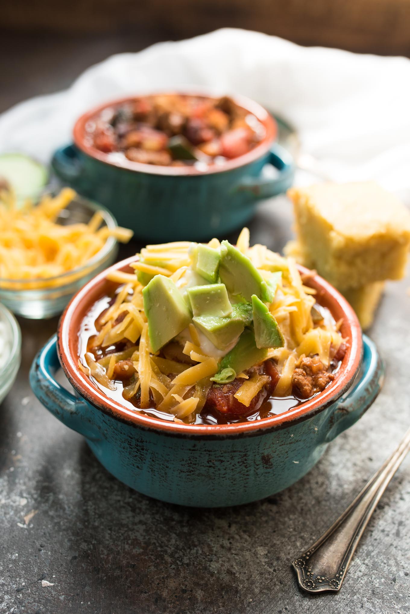 turkey chili in bowl with avocado and cheese