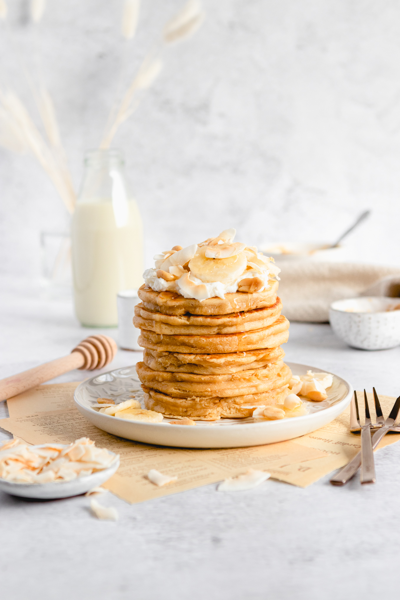 Peanut Butter Pancakes on a plate with whipped cream , banana slices and coconut