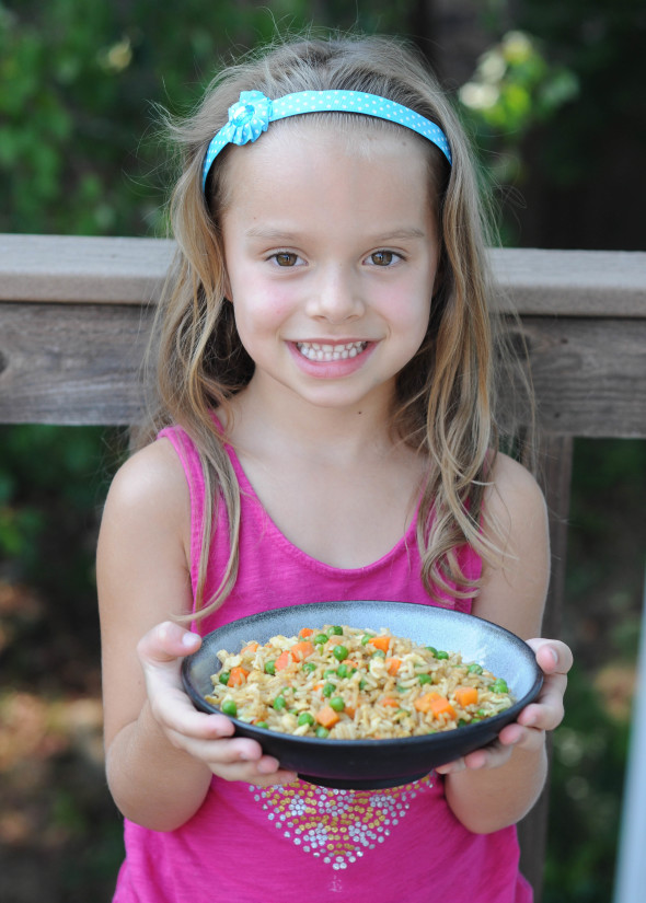 Kid holding a bowl of fried rice 