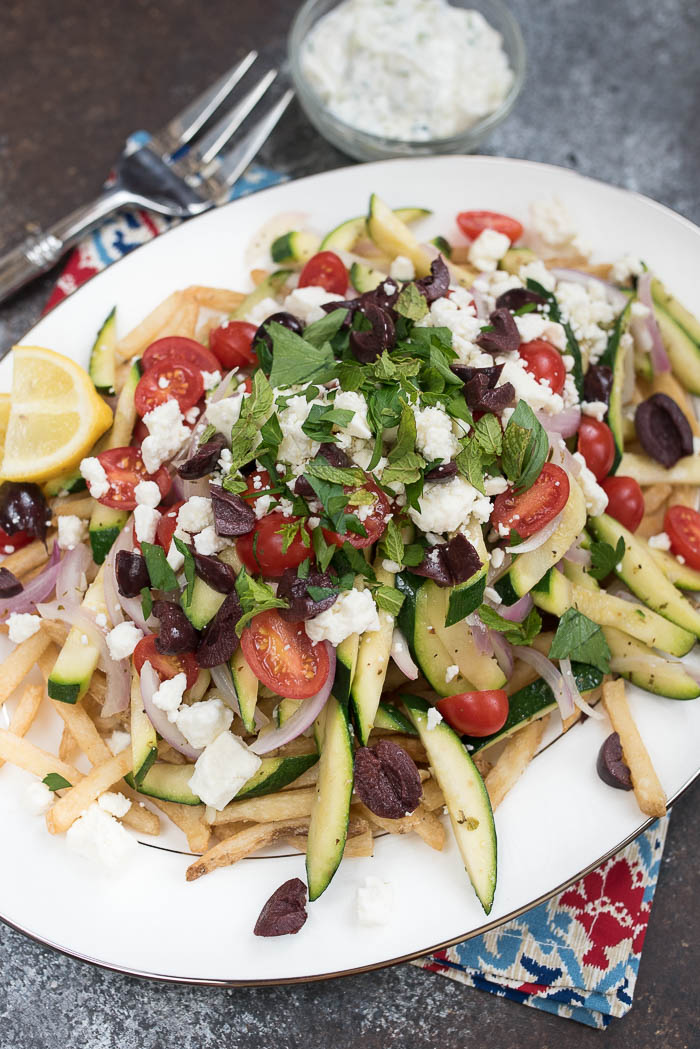 Loaded Mediterranean Fries- Truffle Fries loaded with veggies and Mediterranean flavors like feta, oregano and tzatziki sauce #glutenfree #vegetarian | www.nutritiouseats.com