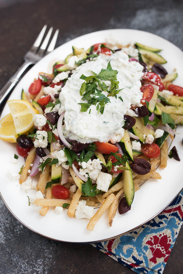 Loaded Mediterranean Fries- Truffle Fries loaded with veggies and Mediterranean flavors like feta, oregano and tzatziki sauce #glutenfree #vegetarian | www.nutritiouseats.com