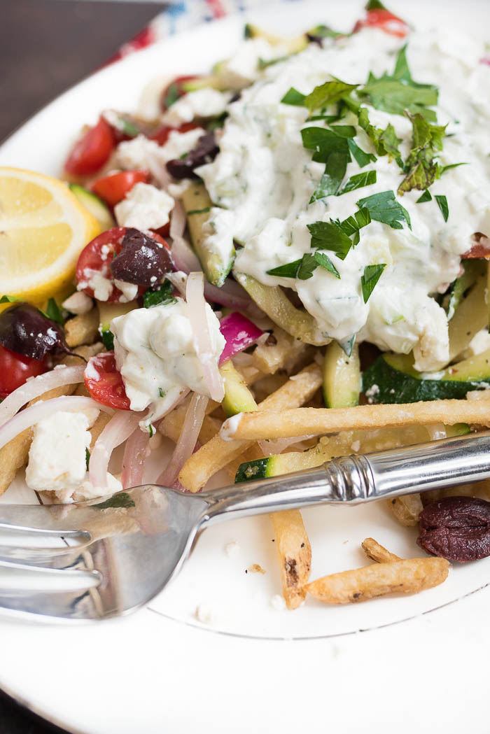 Loaded Mediterranean Fries- Truffle Fries loaded with veggies and Mediterranean flavors like feta, oregano and tzatziki sauce #glutenfree #vegetarian | www.nutritiouseats.com