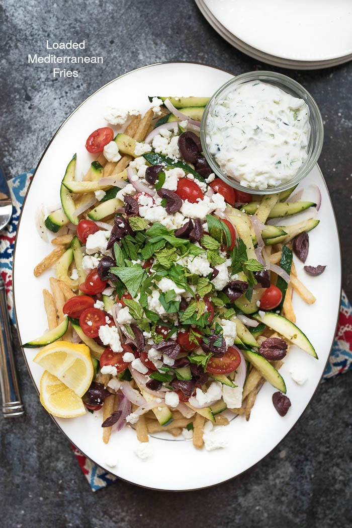 Loaded Mediterranean Fries- Truffle Fries loaded with veggies and Mediterranean flavors like feta, oregano and tzatziki sauce #glutenfree #vegetarian | www.nutritiouseats.com