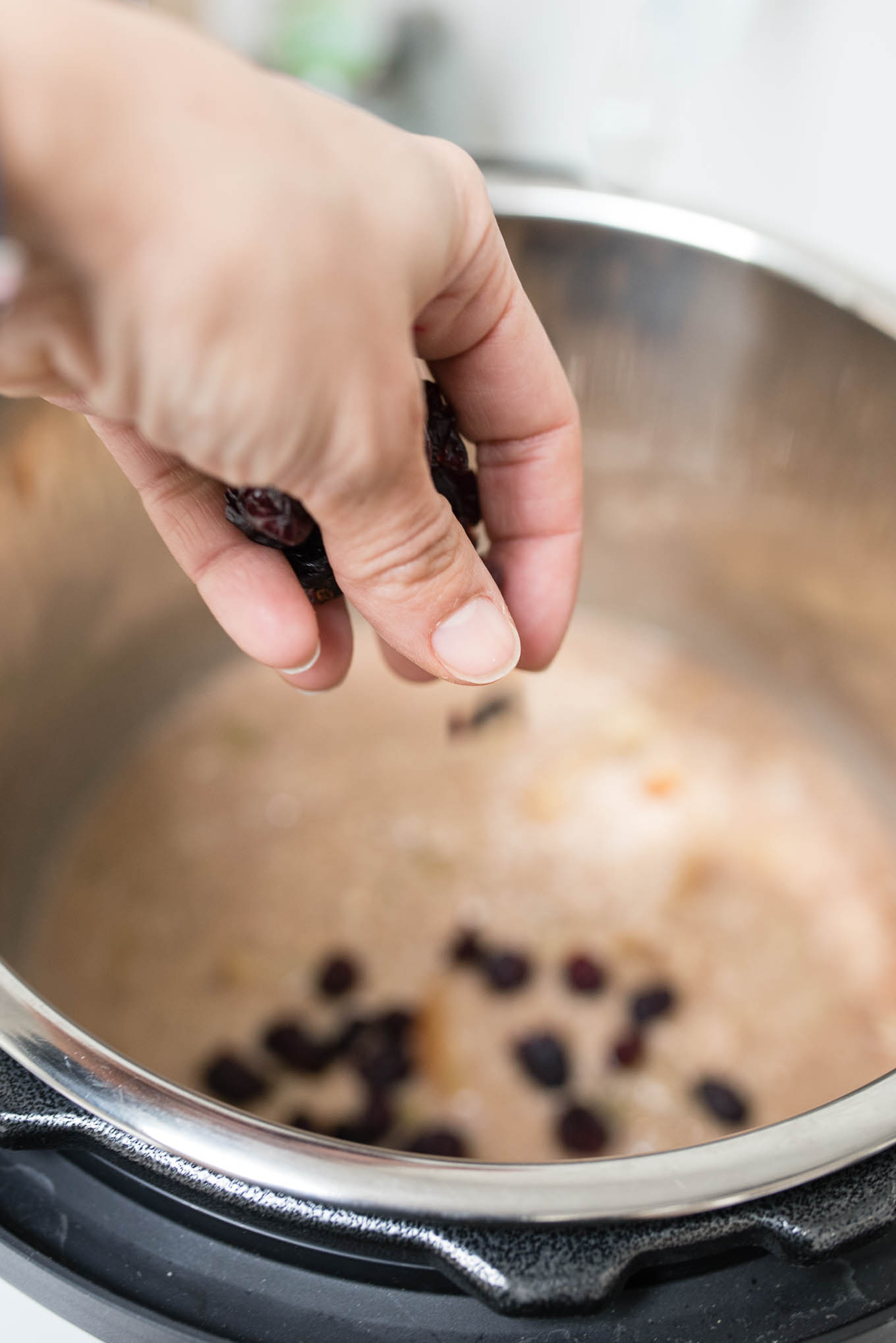 Sprinkling dried cranberries into the Instant Pot oatmeal