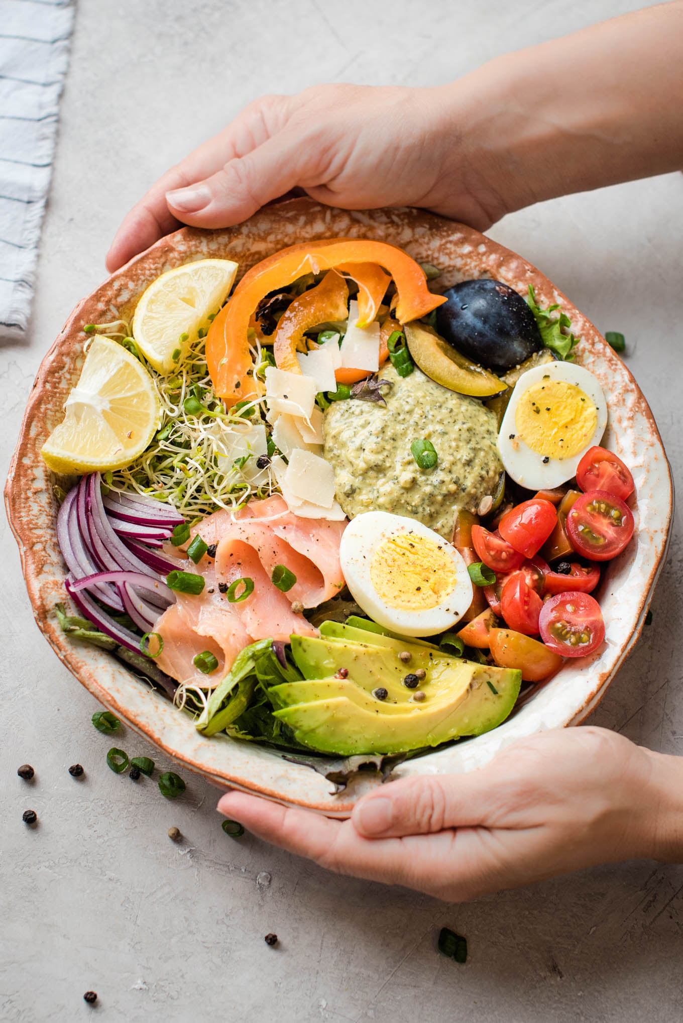 Bowl of vegetables, hummus, egg and salmon