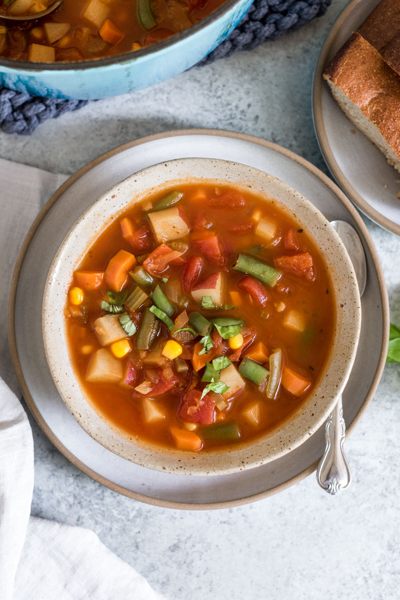 Bowl of vegetable soup with a spoon on the side