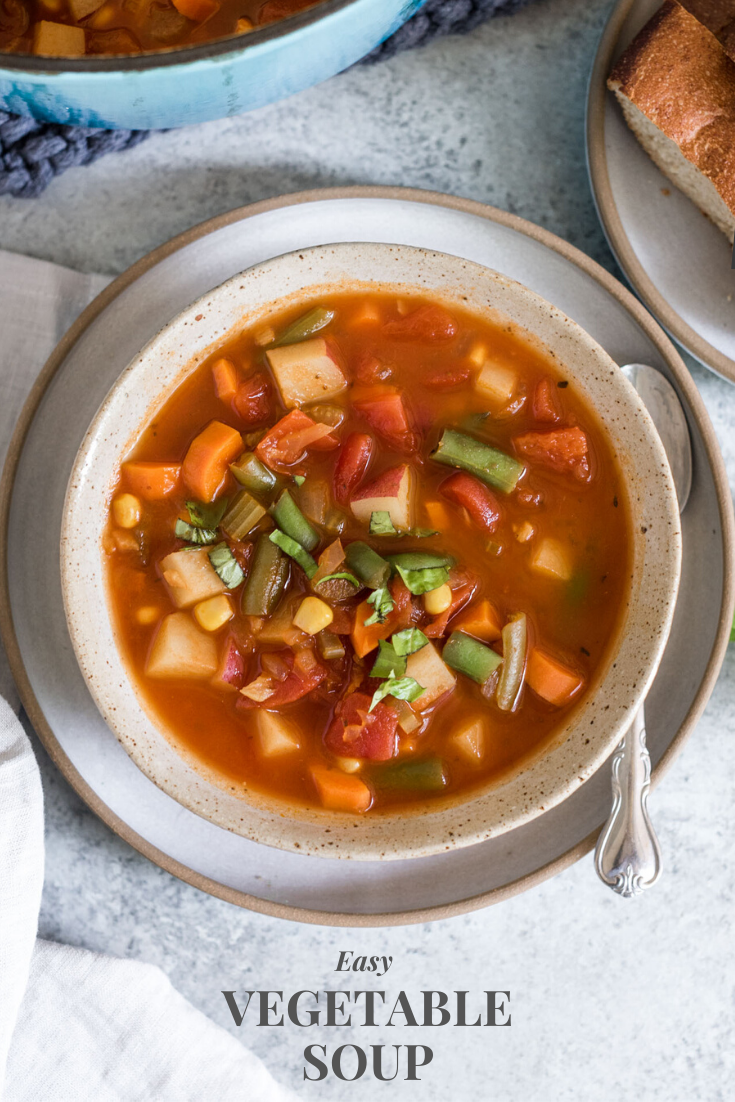 Bowl of vegetable soup with spoon on the side