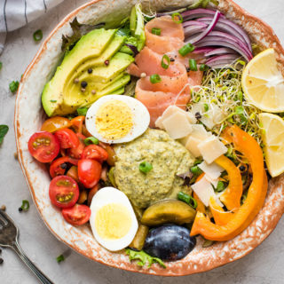 Bowl of vegetables, hummus, egg, salmon