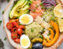 Bowl of vegetables, hummus, egg, salmon